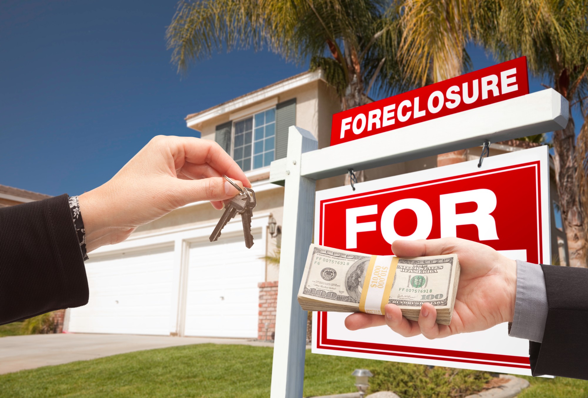 Handing over house keys in exchange for cash in front of a foreclosure sign